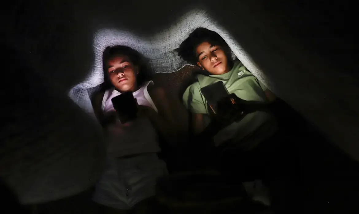 Joédson Alves/Agência Brasil Brasília (DF) 28/01/2025 - Os irmãos Clara Santana (10) e Pedro Santana (13), são vistos com celular na mão embaixo de um cobertor.
Uma a cada 3 crianças tem perfil aberto em redes, alerta pesquisa
Dados foram divulgados nesta terça pela Unico e Instituto Locomotiva
Foto: Joédson Alves/Agência Brasil